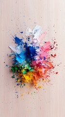 A dynamic burst of colorful powdered pigments, including blue, green, yellow, orange, pink, and white, scattered across a light-colored, textured surface.