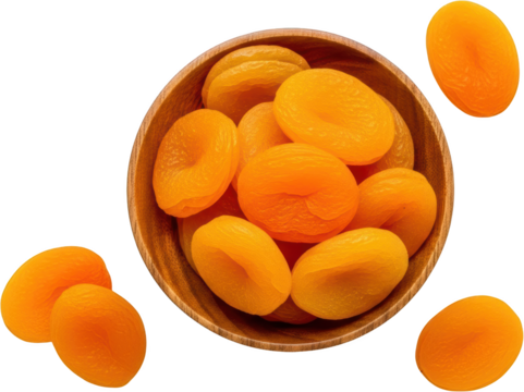 A wooden bowl overflowing with bright orange dried apricots with additional apricots scattered around on a dark background showcasing their textured surface