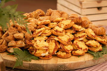 Assorted baked goods displayed on wooden platter with fresh greenery and rustic background
