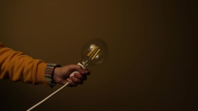 Fast Switch. Hand Quickly Turning Light Bulb On and Off. Blackout Concept. concepts like energy fluctuation, power outage, blackout, a sudden flash of idea, or lost inspiration