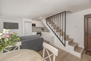 Dining set with a round cherry wood table and chairs with metal frames, adorned with a wildflower bouquet of lavender and wheat stalks