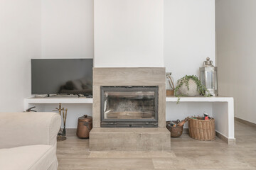 Close-up of a living room with a three-seater sofa in brown leather, a traditional wood-burning fireplace with a metal hood,