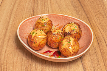 Perfectly golden takoyaki balls coated in tempura tenkasu, served with thick sauce and Kewpie mayonnaise