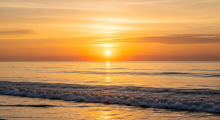 Serene ocean waves gently lap the shore under a warm, golden sunrise sky.