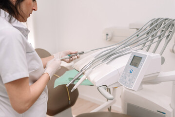 Close up of Female Dentist cleaning dental tools in modern clinic