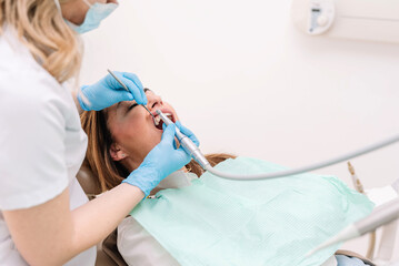 Dentist examining a female patient's teeth during a dental appointment