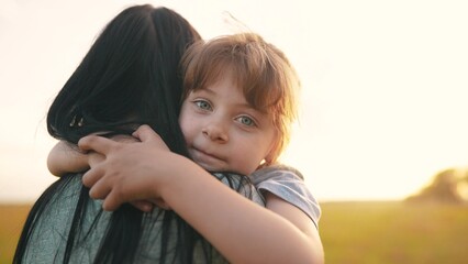 daughter hugging mom. happy family a kid dream concept. mother carries her daughter in her arms walk in the park in nature. child hugging mother neck. mother walks lifestyle with a child in nature © ibragimova