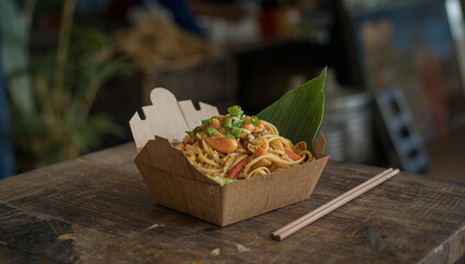 Authentic Pad Thai Noodles in Natural Packaging on Rustic Wood, Famous Thai Street Food and Soft Power Cuisine