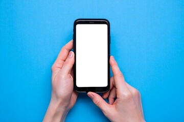 Hands holding smartphone with blank screen mockup on blue background flatlay