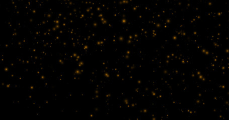 Golden dust particles of various sizes and transparency on a black background. Abstract glowing effect with a warm, festive atmosphere.