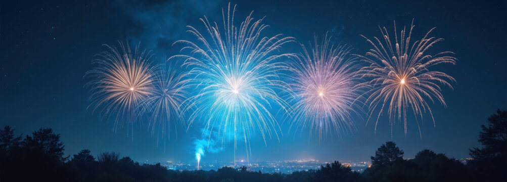 Vibrant blue, pink, gold fireworks explode spectacularly high in dark night sky, illuminating scene. Many lights from distant city glow below festive celebration. Green trees silhouette against