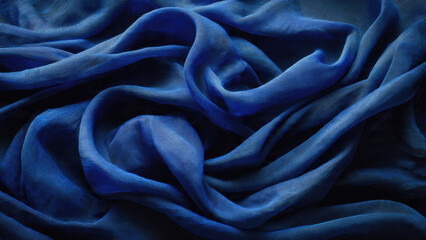 Obraz premium Luxurious blue fabric intricately draped, showcasing soft folds, diverse textures, and varying deep blue shades, creating an elegant, serene abstract pattern.