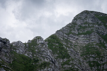 Wide shot of hikers in a distance climbing up steep and rocky ridgeline, Austria