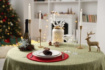 Festive table setting with Christmas decor and burning candles indoors
