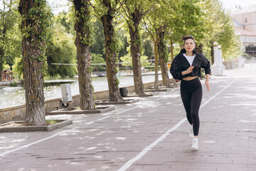 Fototapeta premium Athletic woman running on path in park