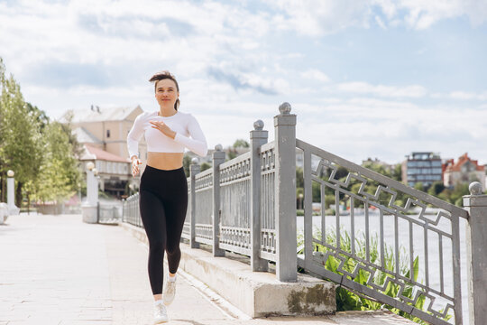 Young woman running outdoors for urban fitness workout - Powered by Adobe