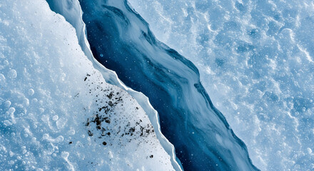 Close-up view of a deep blue crevasse in a glacier, with dark debris scattered on the ice.