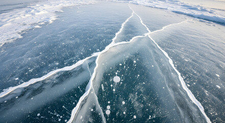 Close-up view of a large crack in the frozen surface of a body of water, with bubbles trapped within the ice.