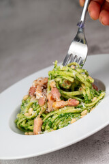 Recipe for linguine pasta with spinach pesto, smoked bacon, and Parmesan cheese. High quality photo