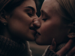 Extreme close-up passionate lesbian couple kissing in forest