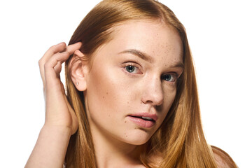 Fototapeta premium Beautiful young woman with striking features and long hair posing elegantly in soft light
