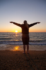 A woman stands on the seashore