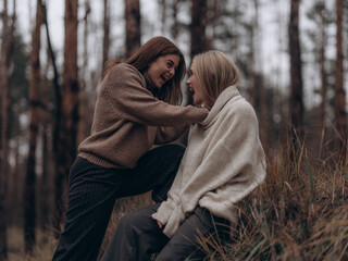 Happy lesbian couple laughing and interacting in forest