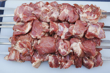 Skewers of marinated meat ready for grilling at a barbecue