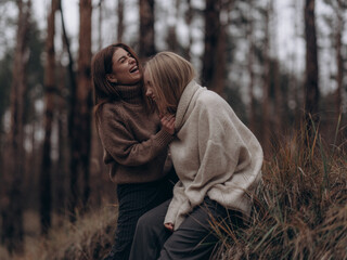 Happy lesbian couple laughing and interacting in forest