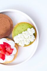 Various kinds of mini cheese tarts on a white plate