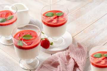 Delicious strawberry panna cotta served on a rustic wooden table for a sweet dessert experience