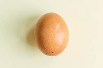 Chicken egg on a yellow pastel background close up, new trend in photography
