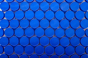 Large group of plastic bottles lined up on a table.