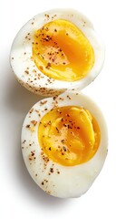 Two halved hard-boiled eggs, yolk and white, sprinkled with pepper