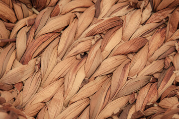 Macro photo of texture of a woven wicker or straw basket. Showing natural earthy tones, fibers and intricate handwoven craftsmanship. Representing of rustic design and traditional handmade artistry.