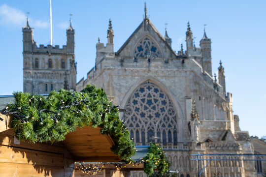 Christmas market on Exeter Cathedral green. Green Christmas spruce with Exeter cathedral behind. Festive celebration.