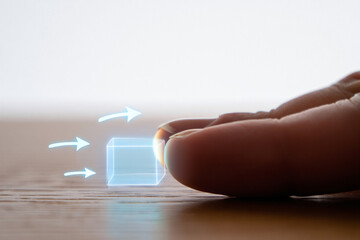 Digital Cube Hovering Near Finger with Three Glowing Arrows on Wooden Tabletop, Innovation and Emerging Technology 150 Characters