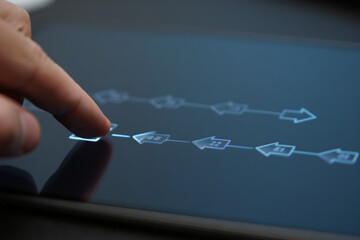 Digital Tablet Displaying Flowchart Being Touched by Finger Presenting Technology and Information with Blue Tones and Light Reflections
