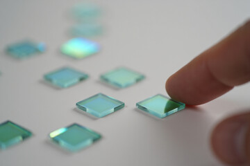 Finger Touching Small Square Glass Tile Placed on White Surface Still Life Concept Minimalist Modern Abstract Artistic Elegant Design