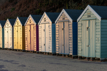 Coloured beach huts in Bournemouth lit by the setting sun muting the colours and invreasing the contrast.