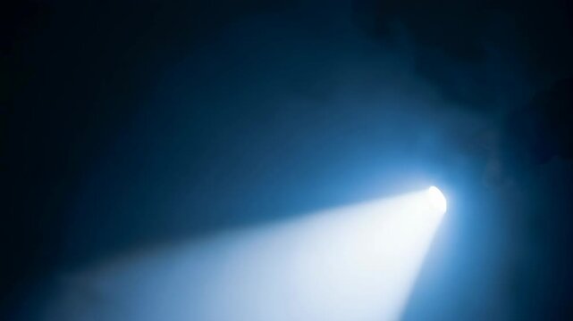 Abstract light beam shining through dark smoke or fog. Light beam creates atmosphere of mystery, suspense or hope for viewers. Light beam serves as conceptual image about possibilities and future.