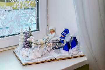 A book with a snowman and a snowflake on top of it on a window sill