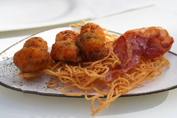 Mediterranean cuisine, Iberian ham croquettes with fried spaghetti and crispy ham