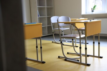 Classroom with yellow desks and chairs at school