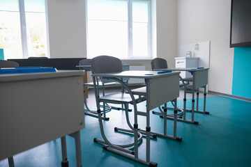 Desk with chairs in classroom at school