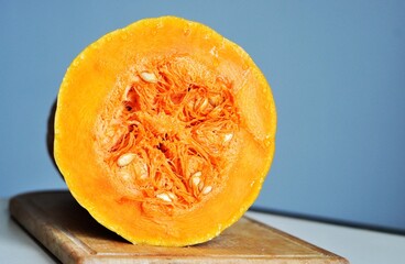 A slice of pumpkin with bright orange flesh and seeds
