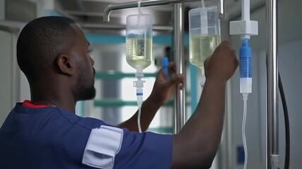 Professional Healthcare Worker Adjusting IV Bags in Hospital Room - Powered by Adobe