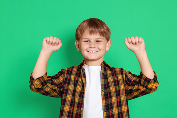 Portrait of cute boy on green background