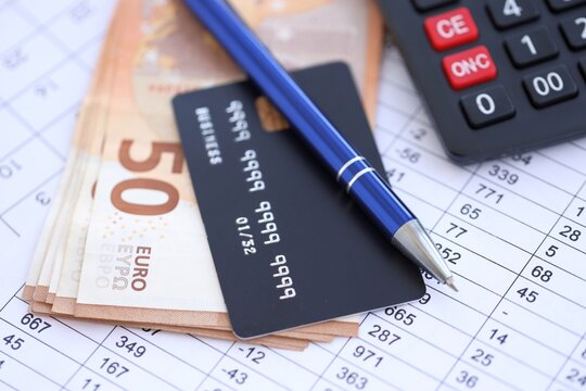 Credit card and pen with euro currency money bills banknotes on calculations document background. Business, financial operations and accounting in European Union - Powered by Adobe