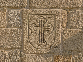 Shield with budded cross embossed in stone, detail of the cathedral of Braga, Portugal 
